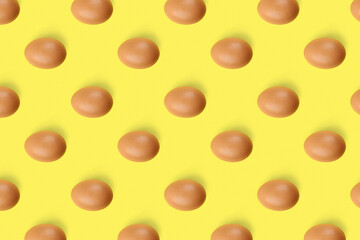 Group of chicken eggs on yellow background, flat lay. Seamless pattern design
