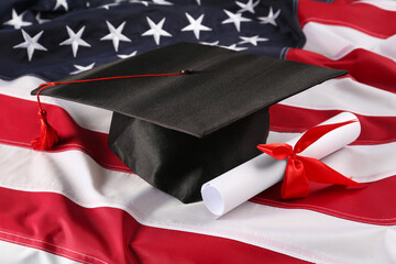 Graduation hat and diploma on flag of United States