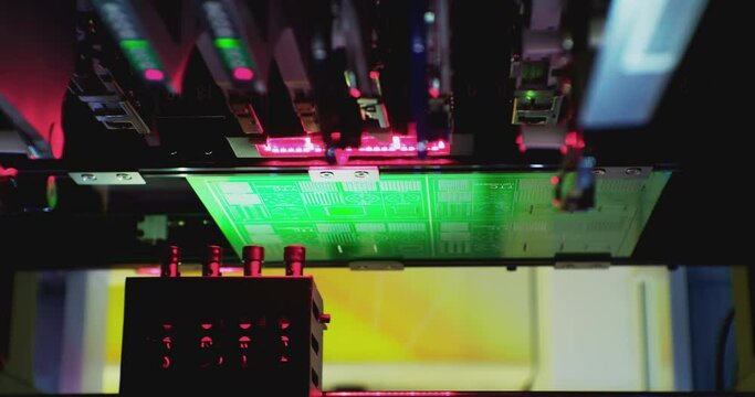 Working industrial robotic machine for the production of electronic printed circuit boards. Close-up microelectronics production.