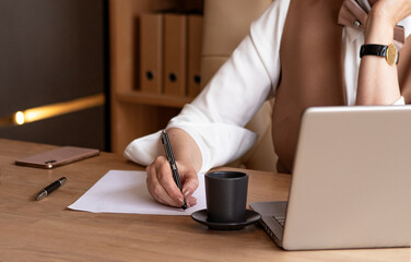 business woman in a beige suit working at the office.