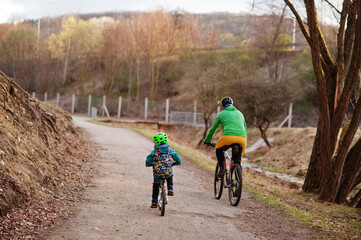 Naklejka premium Back of father with son cycling bike in early spring.