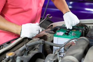 Closeup mechanic fixes car engine, wears gloves and wrench. Check or inspect old car engine for...