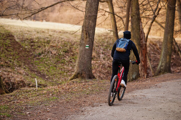 Back of boy cycling bike in early spring.