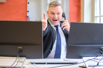 Enthusiastic successful businessman giving a thumbs up