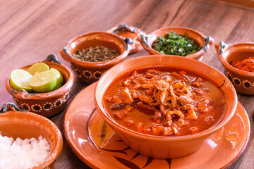 Menudo sobre plato de barro con acompañamientos 