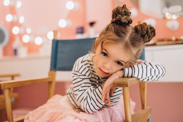 Fototapeta premium Portrait of a little beautiful girl with a stylish hairstyle in a beauty salon