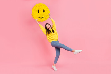 Full body profile side photo of young adorable girl fooling hold paper pinata isolated over pink color background