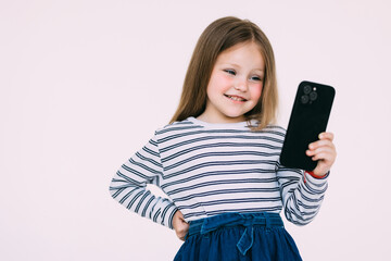 Fototapeta premium little girl looks at the phone isolated on white background