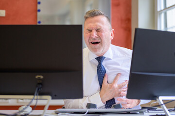 Businessman suffering a heart attack in the office