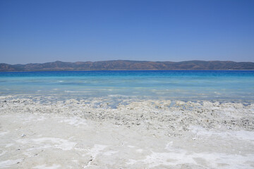Fototapeta na wymiar idyllic beach with white sand and light blue water in sunny day