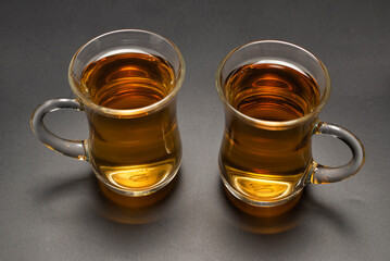 A turkish glass of tea on black background.