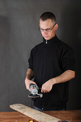 the person holds an angle grinder in his hands