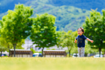 広い公園で日本人の男の子が遊んでいる	
