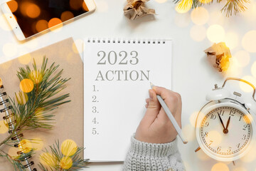 Back to life, goal list concept. Woman's hand writing in empty notebook. Resolutions, plan, goals, checklist, idea concept. Top view, flat lay, copy space. 2022. Christmas, New Year