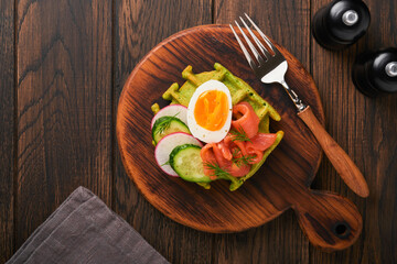 Savory waffles. Breakfast green waffles wild garlic or spinach with egg, tomato, salmon on wooden plate for breakfast on old dark wooden background. Light dinner, lunch or breakfast. Top view. Mock up