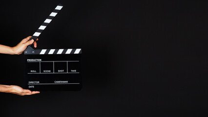 Hand's holding Clapperboard or movie slate use in video production ,film, cinema industry on black background. - obrazy, fototapety, plakaty