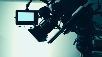 Silhouette images of video camera in tv commercial studio production which operating or shooting by cameraman and film crew team in set and prop on professional crane and tripod for easy to pan tilt o