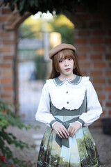 A beautiful woman in lolita dress in garden background Japanese street fashion portrait