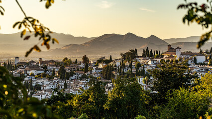 granada at sunset with leafs in foreground spain - obrazy, fototapety, plakaty