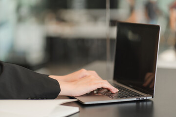 A saleswoman checks the lease and holds a small gray model of house and house keys in preparation for meeting customers to sign the lease. Real estate leasing concept.