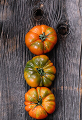 Fresh Costoluto Italian tomatoes, gorgeous taste, wooden background, top view, rustic concept, stock photo