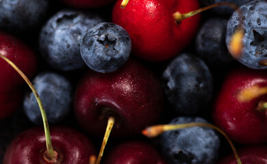 cherries and blueberries mixed together. berry background.