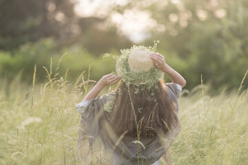 young girl in tall grass at sunset