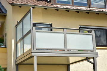 Glasbalkon mit Metall-Geländer und Glasplatten als Sturz-und Sichtschutz am mittleren Geschoss...