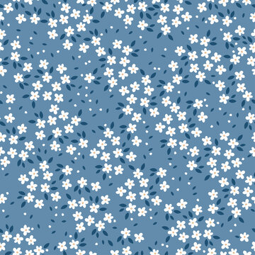 Seamless pattern with white flowers and blue background