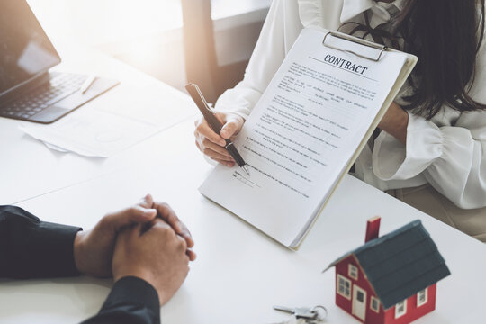 Guarantee, Mortgage, agreement, contract, Signing, Male client holding pen to reading agreement document to sign land loan with real estate agent or bank officer.