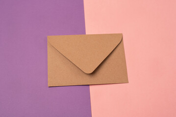 Craft envelope on a two-colored pink and purple background.  