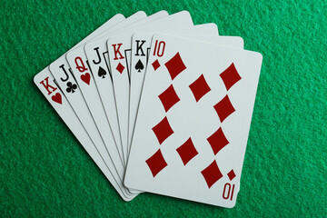 Playing cards on green table, top view