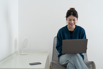 Happy smiling woman sitting on sofa, couch and using laptop at living room at home, watching funny video, learning language, video calling, mother working online