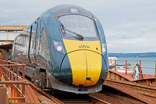 Dawlish, England - May 12, 2022: A Great Western Railway inter city passenger train departing the town’s station. The company provides rail links to Wales and the West of England from London