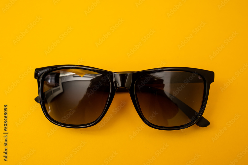 Wall mural black s sunglasses on orange background