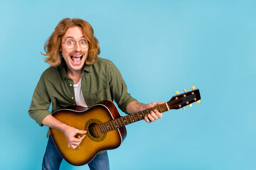 Portrait of attractive cheerful funky guy playing guitar rock hit singing having fun isolated over...
