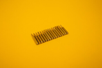 Small screwdriver bits on a yellow background