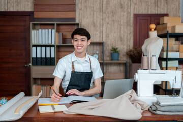 Young Man Asian LGBTQ Tailor Shop Owner,The typist chats with the customer about cutting the dress, with a happy face,Small business Professional Design clothes to sell online.