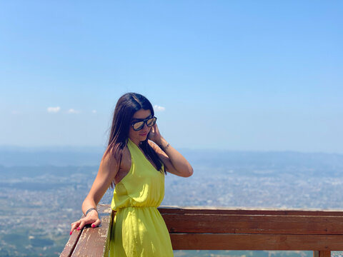 Woman traveler on mountain top lookig at city from height. Tirana city view from mountain Dajti, Albania