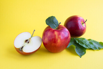 Closeup on red apple on the yellow background. Copy space.