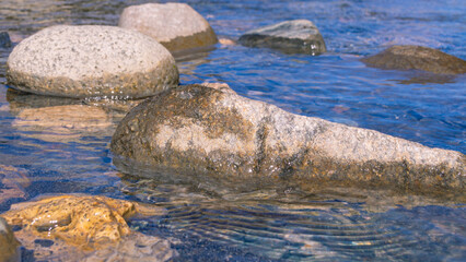 A mountain river with clear and transparent water. Landscape with a view of gray stones in a mountain river. Clean water and healthy water.