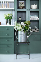 Vintage rustic garden Tool at home. Summer bouquet of flowers in watering can on chair. Bunch of...