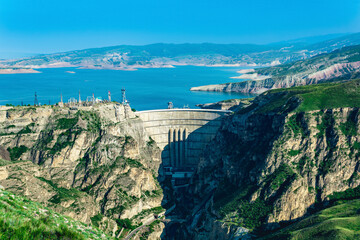 Plakat mountain landscape with an arched hydroelectric dam and a reservoir in the canyon