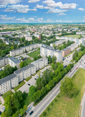 drone picture of quiet living area in the town, high residential buildings can be seen and trees in between 