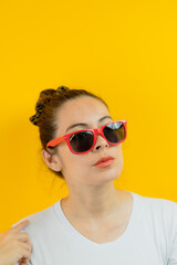 casual woman thinking or wanting with her red glasses and a yellow background very casual and very beautiful