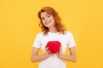 happy young girl holding valentines heart on yellow background, 14 february