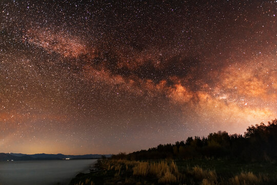 Beautiful night landscape milky way galaxy at the night sky over the lake. © Inga Av
