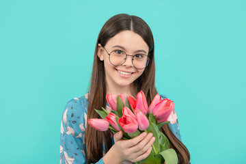 smiling child portrait in glasses with tulips. mothers or womens day. kid hold flowers