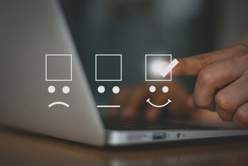 Close up image of hand holding on smily icon and selecting smiley face icon and a 5 star rating....