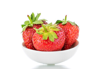 Three berries of ripe organic strawberries on a white ceramic saucer, close-up, isolated on a white background.